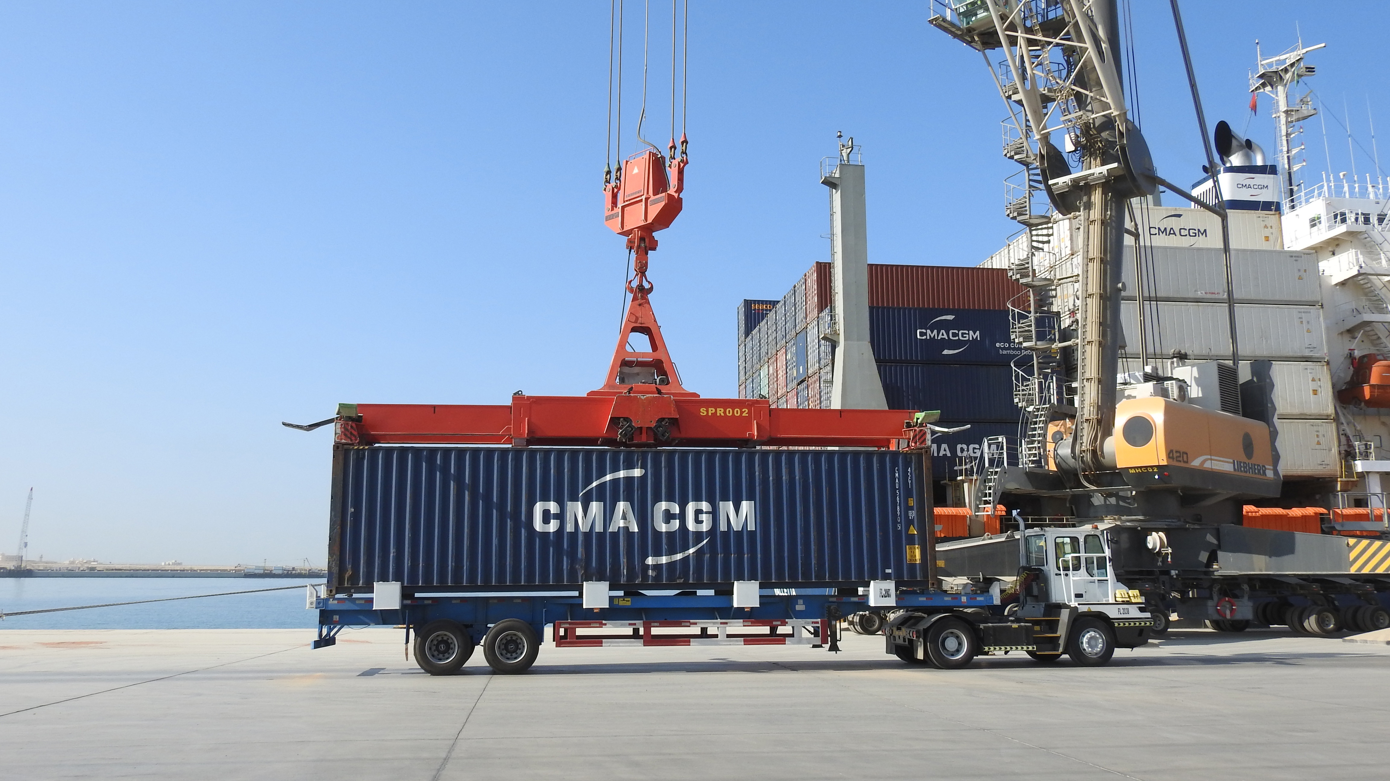 A container being loaded directly onto a truck at Port of NEOM